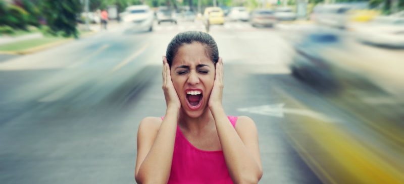 Femme se bouchant les oreilles avec ses mains