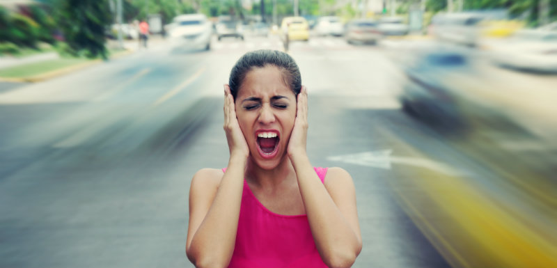 Femme se bouchant les oreilles avec ses mains