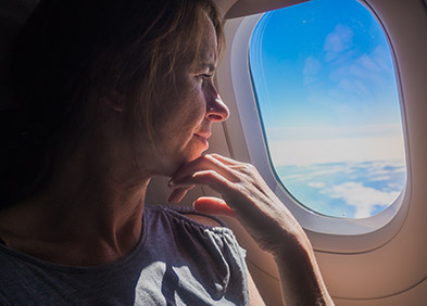 Femme regardant par le hublot d'un avion