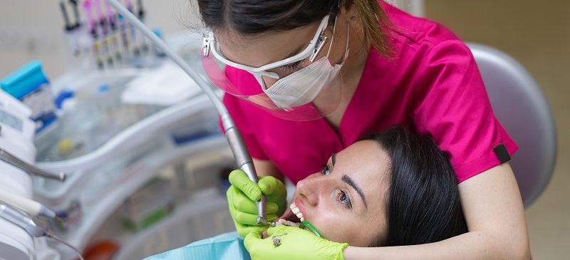 Une dentiste nettoie les dents d'une patiente dans une clinique dentaire