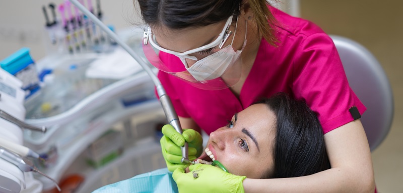 Une dentiste nettoie les dents d'une patiente dans une clinique dentaire