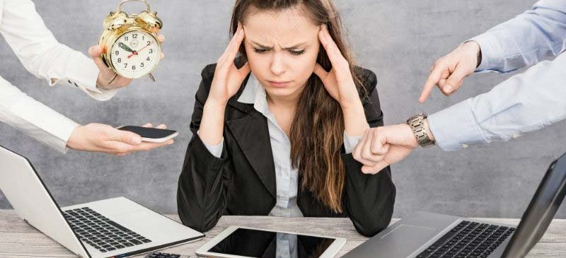 Femme stressée devant plusieurs écrans