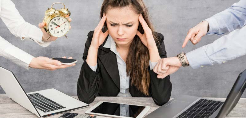 Femme stressée devant plusieurs écrans