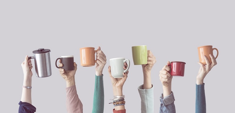 Plusieurs bras levés avec une tasse de café dans la main.