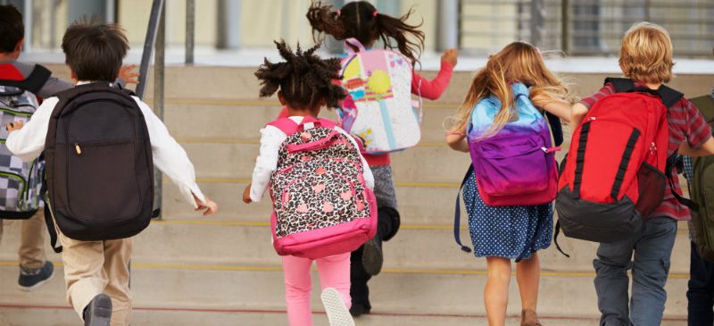 enfants qui courent avec leur cartable sur le dos