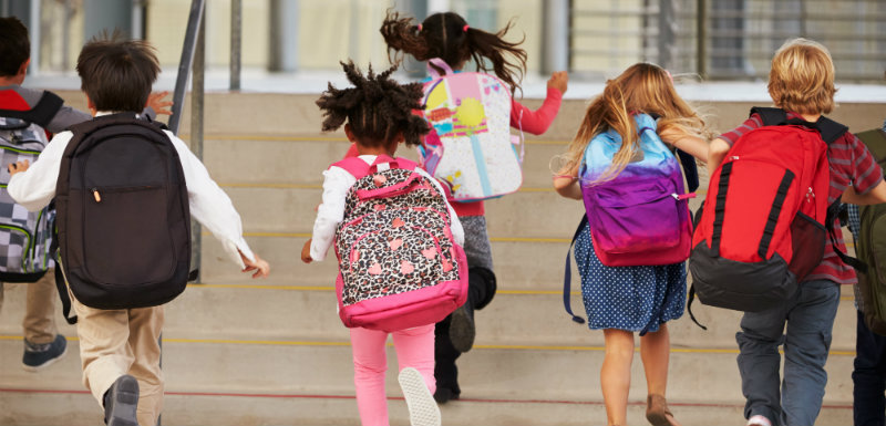 enfants qui courent avec leur cartable sur le dos