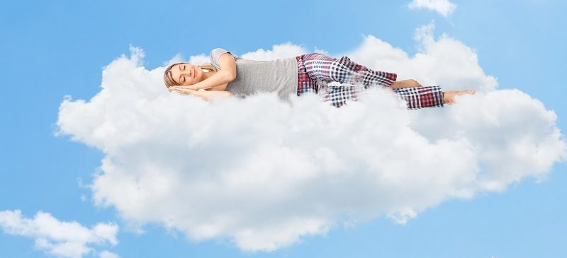 une femme entrain de s'endormir tranquillement sur le nuage