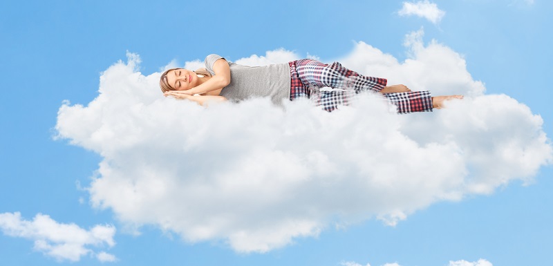 une femme entrain de s'endormir tranquillement sur le nuage