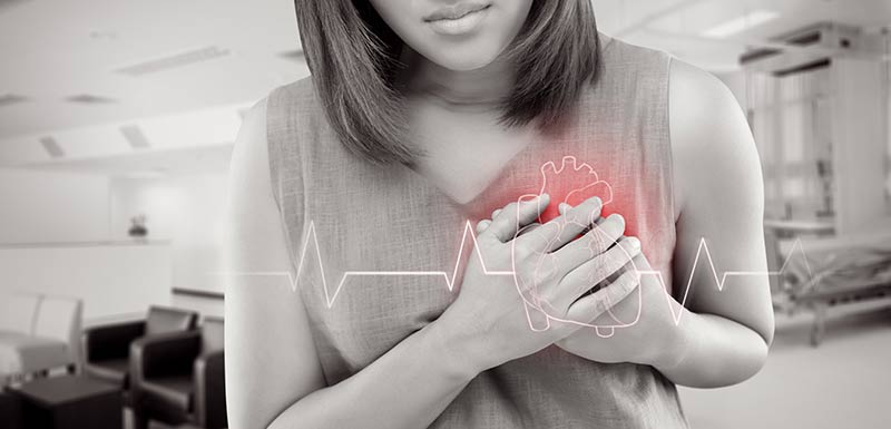 une femme se tient les mains sur le coeur, diclofénac risques cardiaques