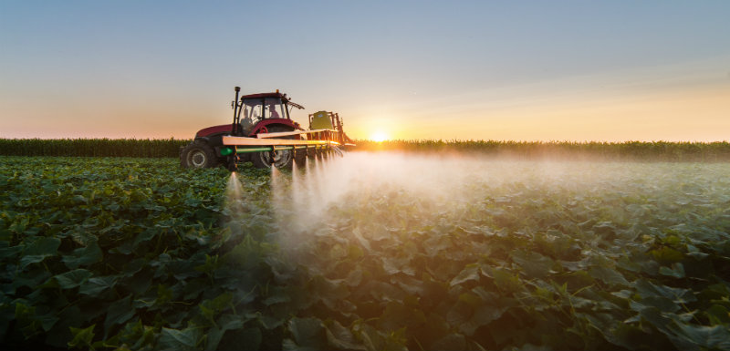 tracteur vaporisant des pesticides dans un champs