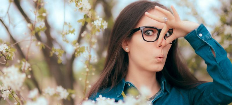 Femme qui se pince le nez car elle est allergique au pollen