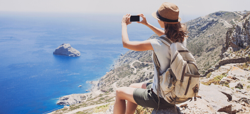 Femme en haut d'une montagne qui profite du paysage de bord de mer