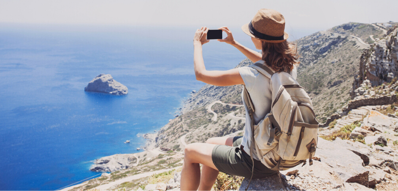 Femme en haut d'une montagne qui profite du paysage de bord de mer