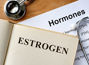 Estrogen écrit sur un livre avec une liste d'hormones pour un bilan hormonal d'infertilité féminine