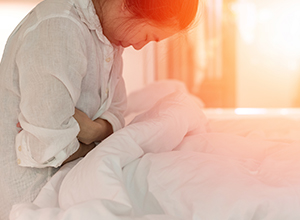 Jeune femme ayant des souleurs menstruelles et des maux d'estomac à cause de la grossesse extra-utérine