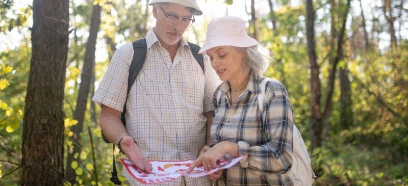 Un couple de personnes âgées réalisant un test d'orientation en pleine forêt