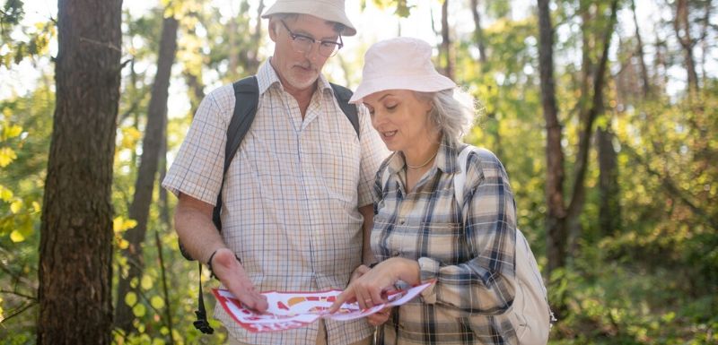 Un couple de personnes âgées réalisant un test d'orientation en pleine forêt 