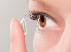 Femme qui se met une lentille de contact dans l'oeil