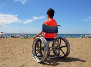 Jeune homme en fauteuil roulant à la plage