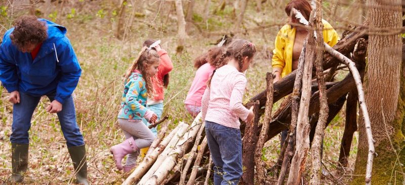 Groupe d'enfants qui jouent ensemble dans un bois en colonie