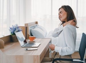 Femme qui a mal en haut du dos