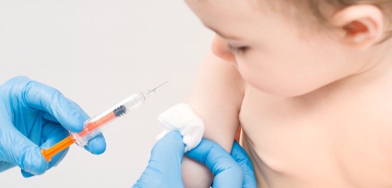 petit enfant qui se fait vaccincer par un professionnel de santé