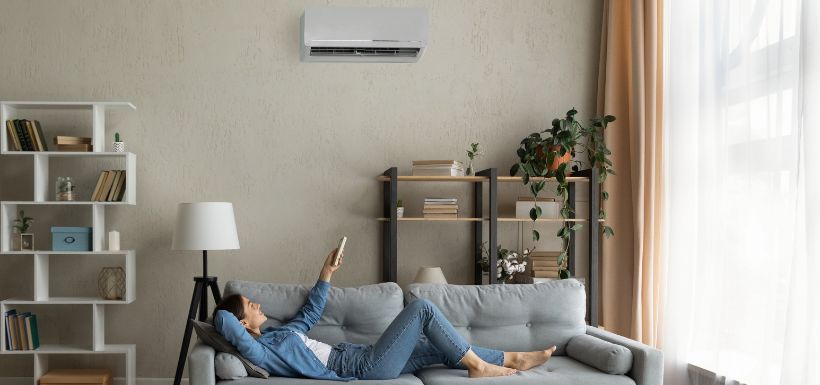 femme qui fait fonctionner sa climatisation en pleine canicule