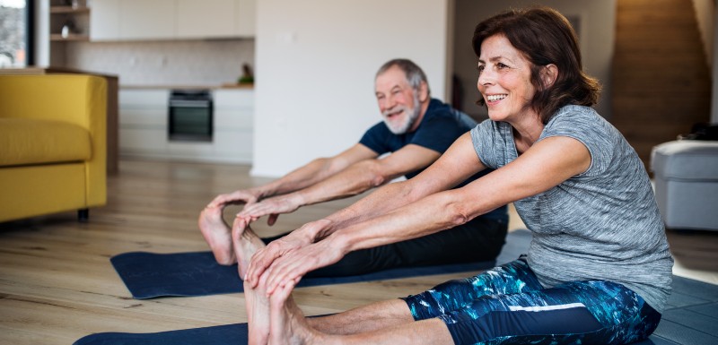 Couple d'adultes qui s'étirent sur un tapis de sol 