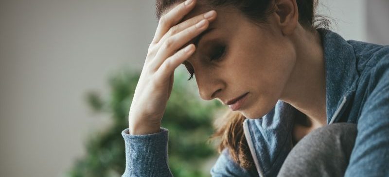 Femme fatiguée se tenant la tête dans la main