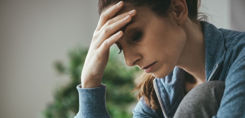 Femme fatiguée se tenant la tête dans la main