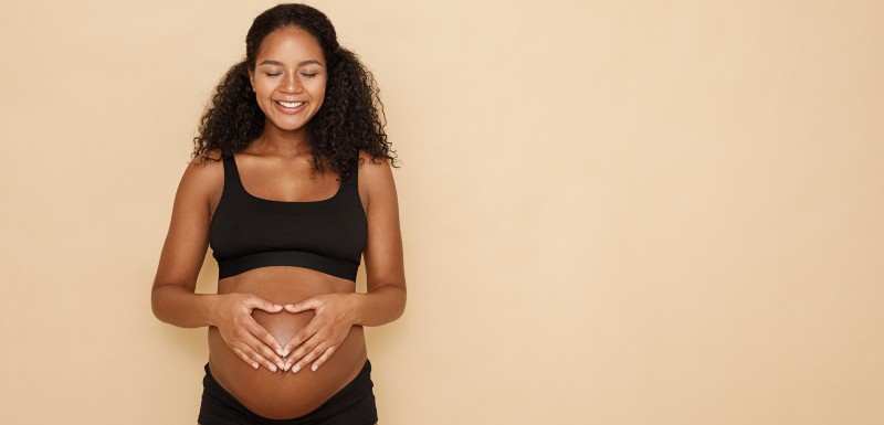 Jeune femme toute souriante qui attend un bébé