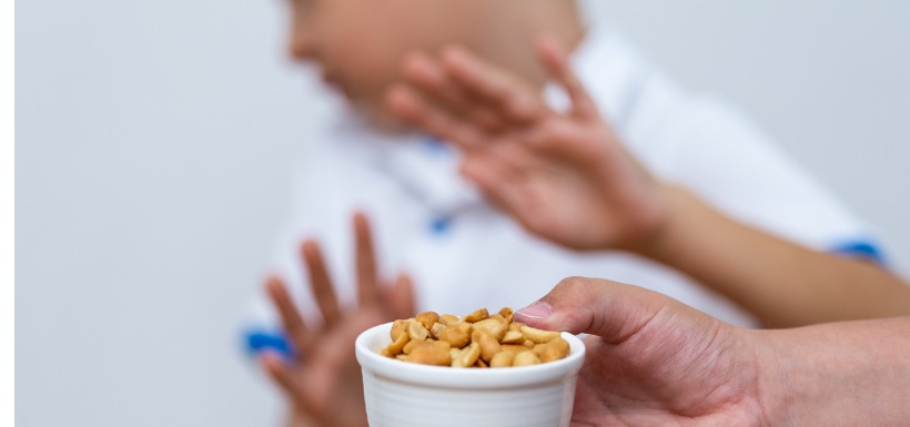 homme repoussant un bol de cacahuètes 