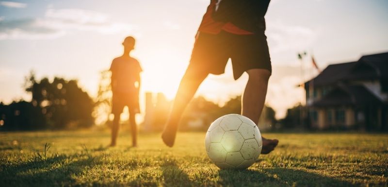 Silhouette d’enfant en plein air s'amusant à jouer au football pour faire de l'exercice.