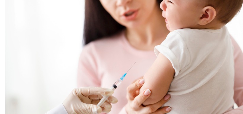 bébé se faisant vacciner dans les bras de sa mère 