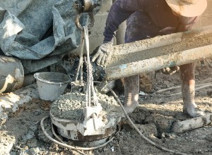 un ouvrier sur un chantier faisant couler du béton 