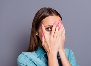 femme qui se cache les yeux car elle a peur