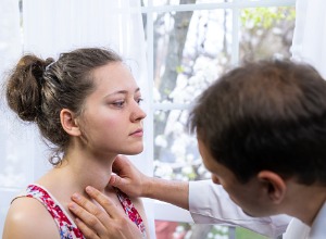 médecin regardant le cou d'une patiente 