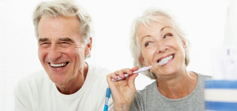 personnes qui sourient en se brossant les dents en pensant à l'offre santé dentaire