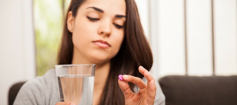 femme qui pend la pilule du lendemain