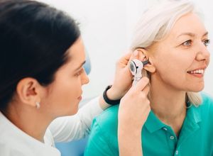 médecin qui regarde dans l'oreille d'une femme