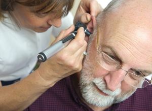 médecin qui regarde dans l'oreille du patient