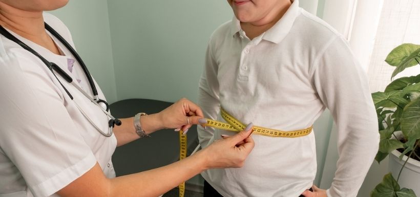 médecin qui mesure le tour de taille d'un petit garçon