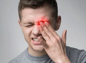 un garçon qui a une douleur à l'œil