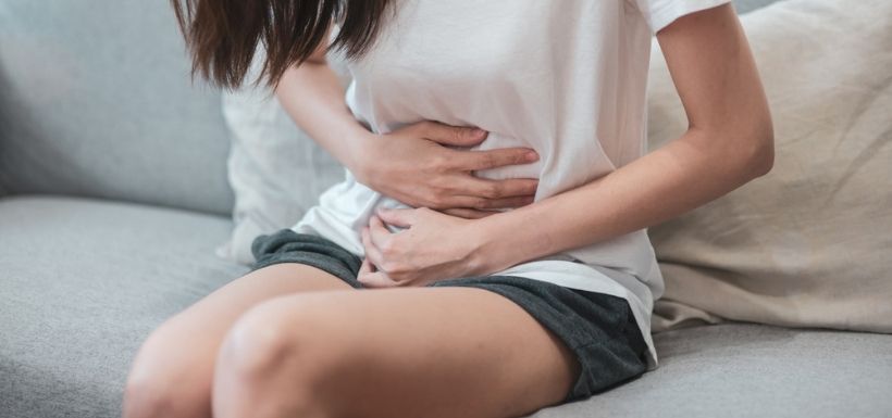 Femme ayant des douleurs au ventre après avoir ingéré un corps étrangé