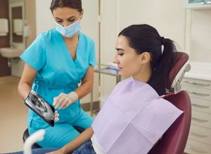 dentiste et son patient qui regardent la radiographie d'une mâchoire