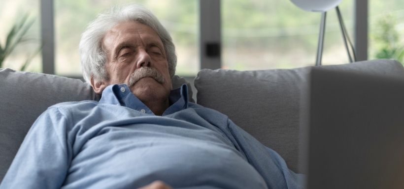 monsieur âgé qui se repose dans son canapé