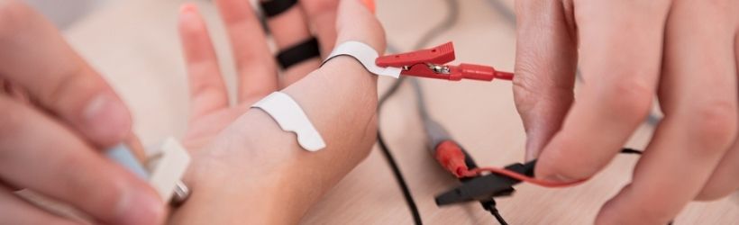 médecin qui effectue des tests sur un patient par électromyographie