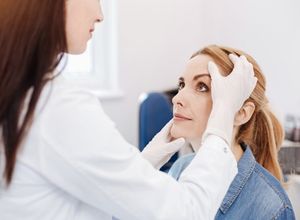 un médecin en train de faire le diagnostic d'une paralysie faciale chez un patient