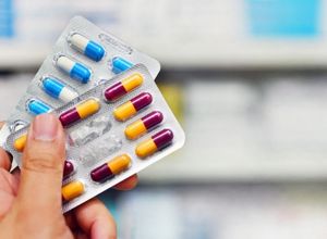 personne qui tient des plaquettes de médicaments