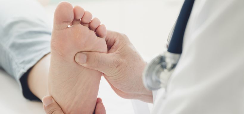 médecin qui regarde un pied